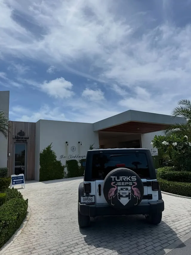 A white Turks Jeeps Wrangler waiting in a resort driveway